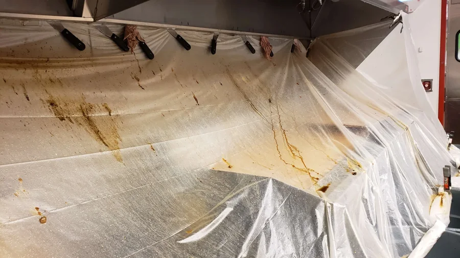 Plastic sheeting protecting equipment beneath a commercial hood